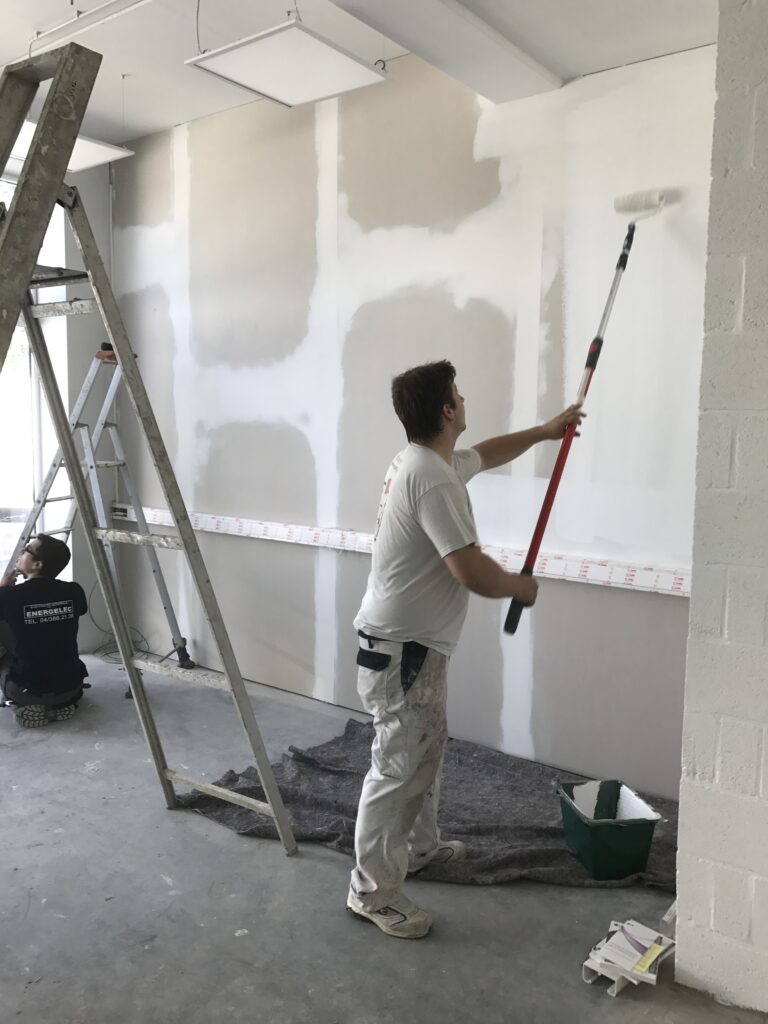 peintre applique une couche de peinture